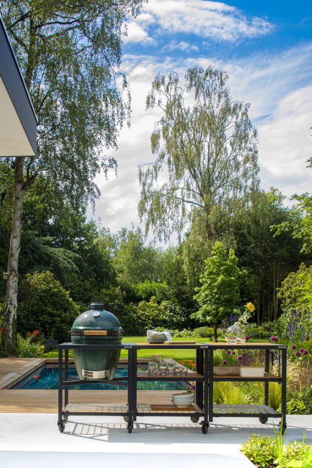 Big Green Egg in stilvoller Outdoor-Küche im Garten - ultimatives Grillerlebnis und vielseitige Zubereitungsmöglichkeiten.