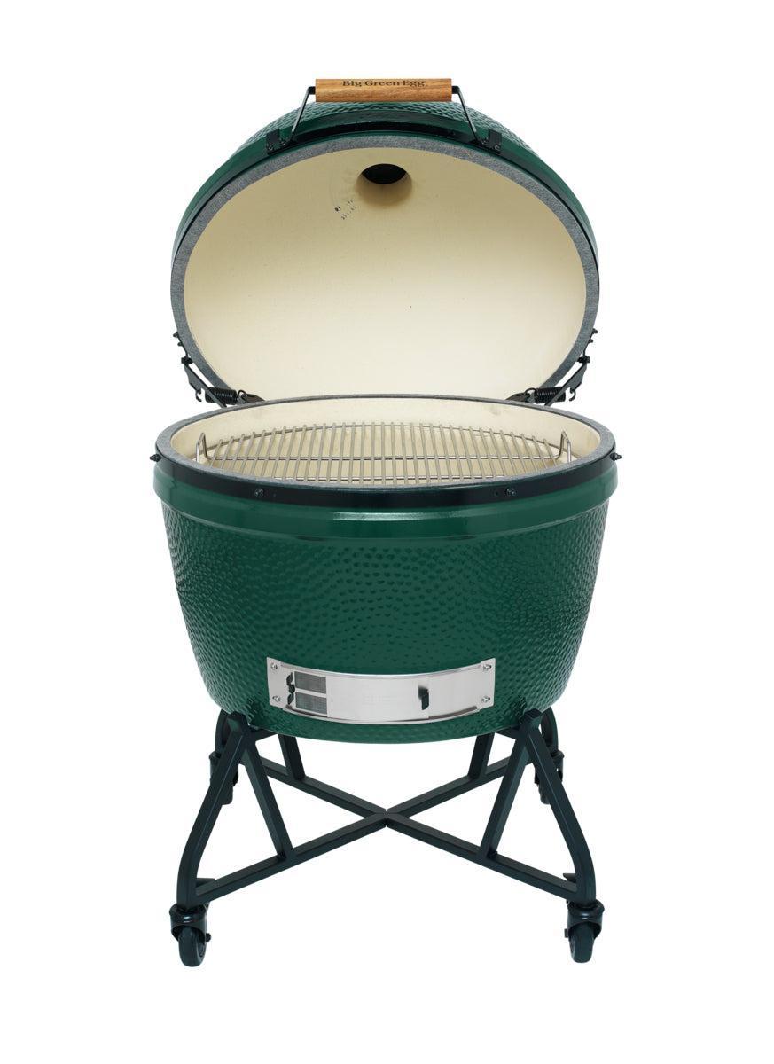 Big Green Egg 2XL mit aufgeklapptem Deckel auf schwarzem Nest, Blick auf Edelstahlrost und helle Keramik-Brennkammer.