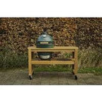 Big Green Egg in einem Eukalyptustisch mit Rollen im Garten vor einer Laubhecke