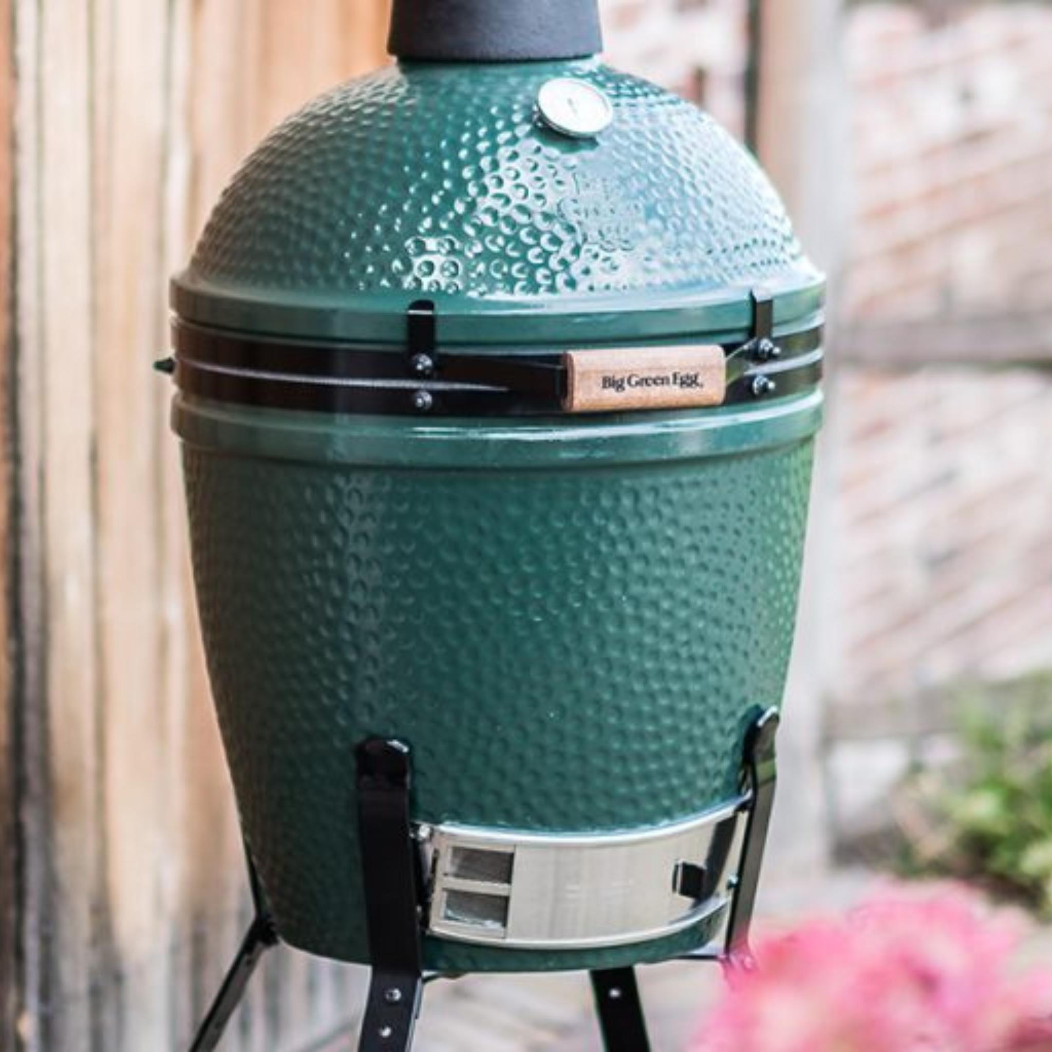 Big Green Egg Medium auf dem Nest-Untergestell vor einer Backsteinwand