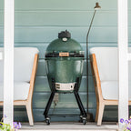 Big Green Egg Medium auf fahrbarem Nest zwischen zwei Loungesesseln auf der Terrasse