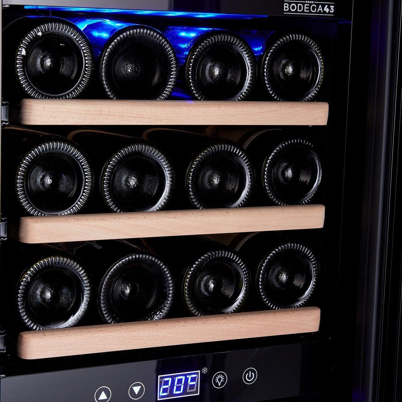 Liegende Weinflaschen auf Holzregalen im Bodega 43 B4324L mit Temperaturanzeige im Detail