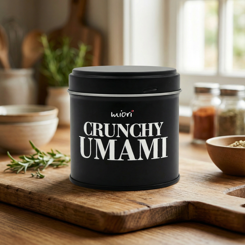 Crunchy Umami Dose auf Holzbrett in heller Küche, daneben Rosmarin und Gewürzschälchen