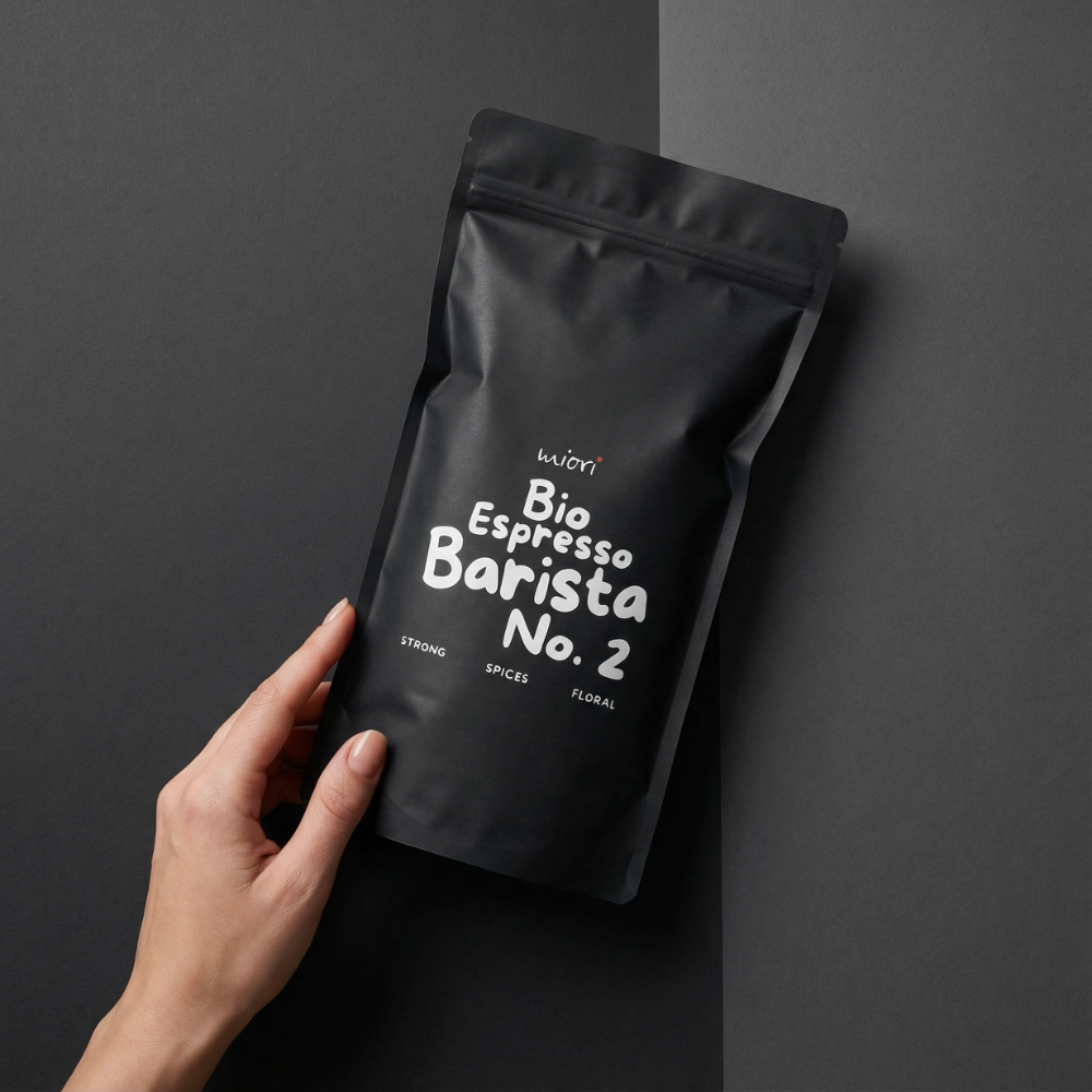 Hand hält Bio Espresso Barista No. 2 Beutel vor grau abgesetztem Hintergrund