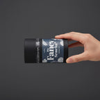 Hand hält liegende Bio Fancy Sencha Dose vor grauem Hintergrund