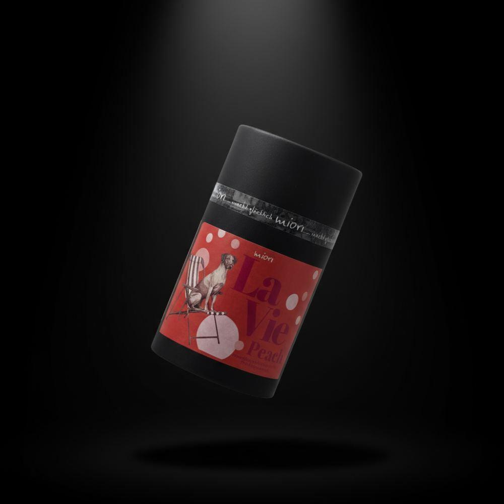 La Vie Peach Teedose frontal vor schwarzem Hintergrund, schwarze Röhre mit rotem Hundemotiv-Etikett