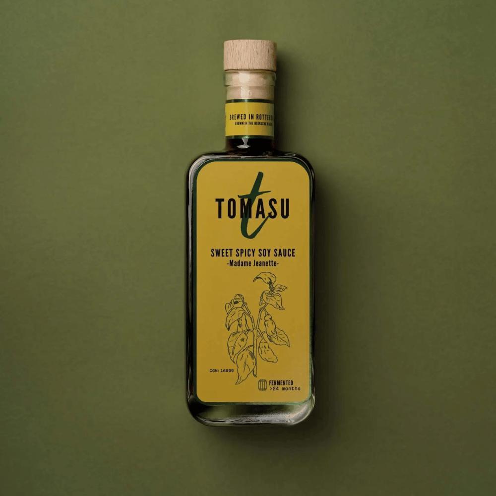 Flasche der Tomasu Sweet & Spicy Sojasauce – Madame Jeanette auf olivgrünem Hintergrund. Hochwertige, mikrogebraute Sojasauce aus Rotterdam mit fermentierter Schärfe bei miori