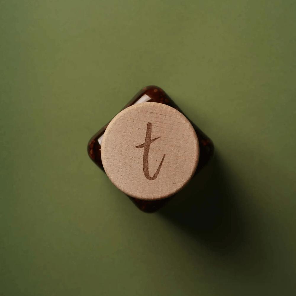 Holzdeckel des Tomasu-Sambal-Glases mit eingraviertem t-Logo, von oben fotografiert