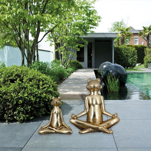 Goldene Skulpturen von meditierenden Froschfiguren in einem Garten in Saarbrücken, symbolisch für Ruhe und Gelassenheit von Miori Gartenobjekte."