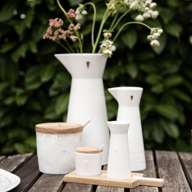 Porzellan-Karaffen auf Gartentisch mit Marmeladendose und Milch-Zucker-Kännchen - stilvolle Tischdekoration für besondere Anlässe.